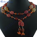Load image into Gallery viewer, A close-up shot of a stunning carved gemstone necklace. The necklace is strung with beads of different shapes and colors.