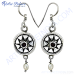 Load image into Gallery viewer, Sterling silver drop earrings featuring a circular design, dark gemstone center, and white pearl drop.