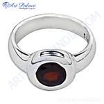 Load image into Gallery viewer, Sterling silver ring with a vibrant red oval-cut garnet gemstone.