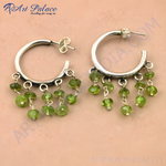 Load image into Gallery viewer, Sterling silver hoop earrings with dangling peridot gemstones in a vibrant green color.

