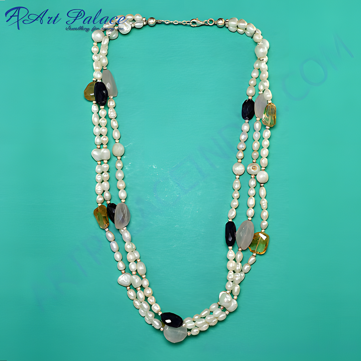 Multi strand pearl necklace with black onyx, yellow, and gray gemstones on a teal background
