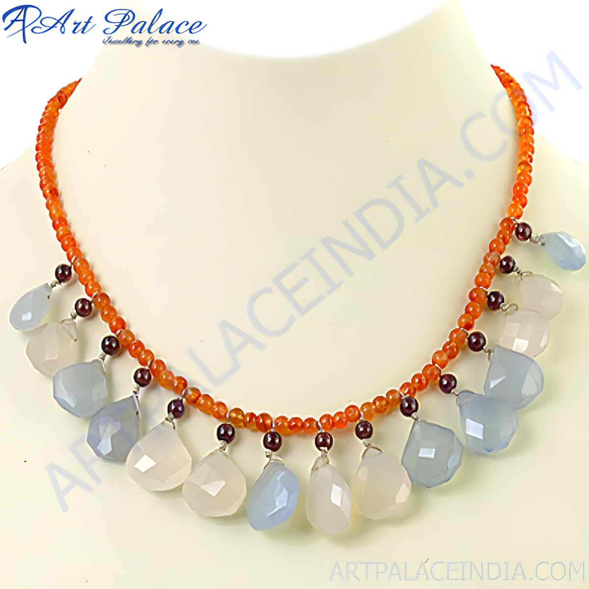 A beaded necklace with orange beads and teardrop shaped chalcedony and garnet gemstones