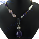 Load image into Gallery viewer, A stunning gemstone beaded necklace featuring purple, pink, and clear stones on a black display.
