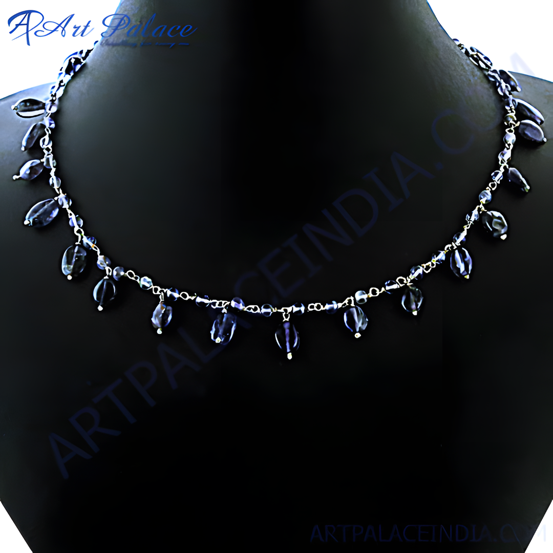 Silver gemstone beaded necklace on a black background. Delicate chain necklace with blue teardrop stones.