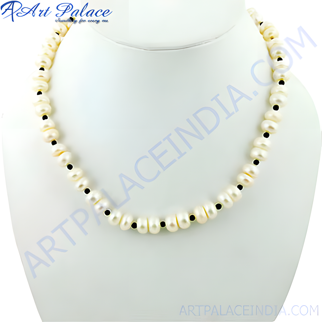 Elegant freshwater pearl necklace with black onyx bead accents on a white display.