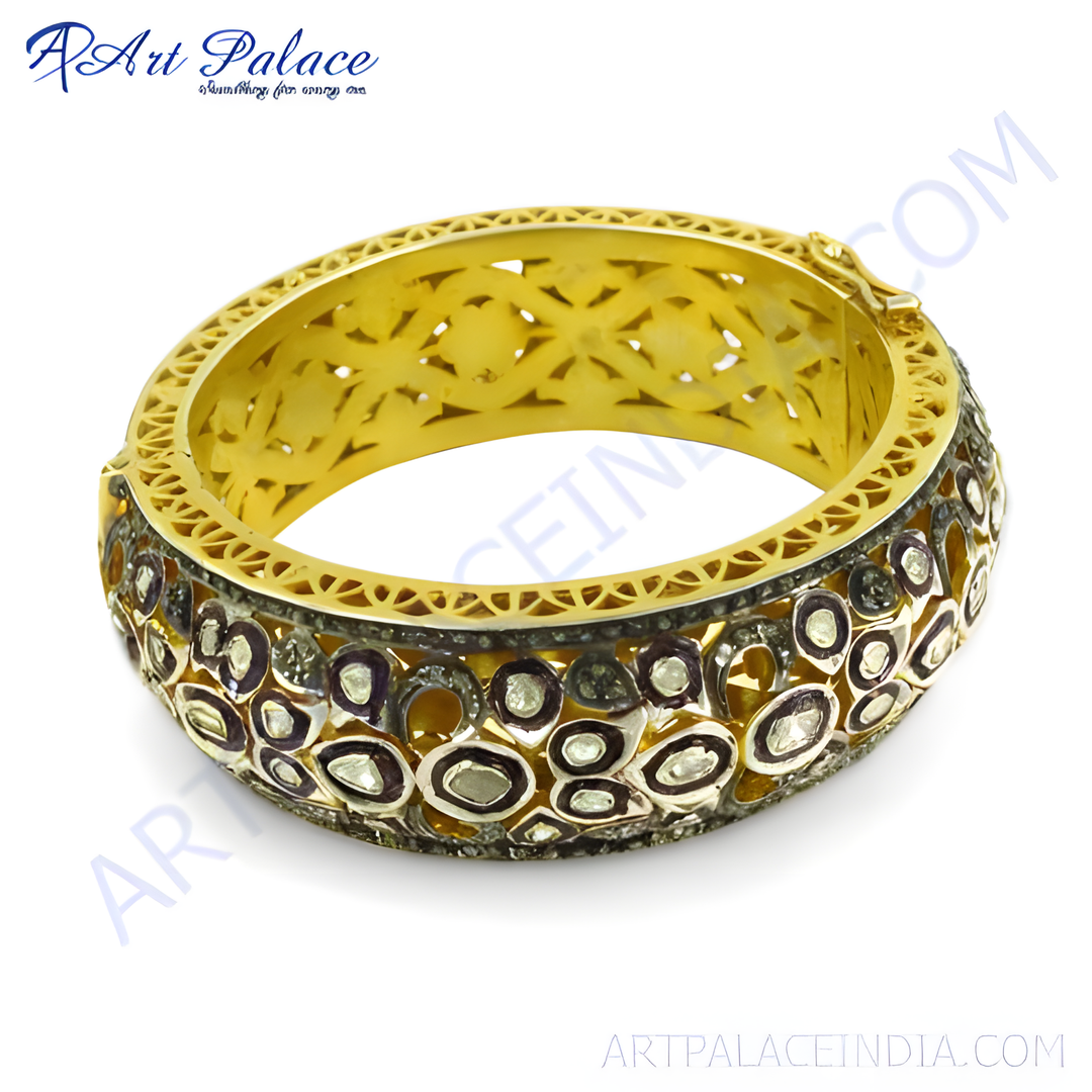 Gold bangle bracelet with intricate design and diamonds. Luxury jewelry for women. Elegant and stylish.