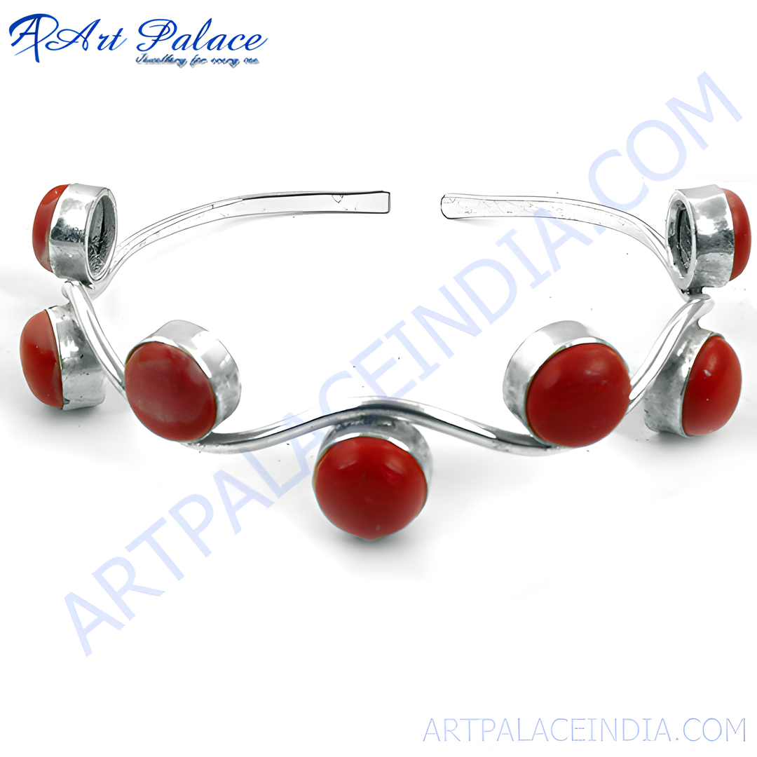Silver bangle bracelet with red coral stones, a statement piece of jewelry.