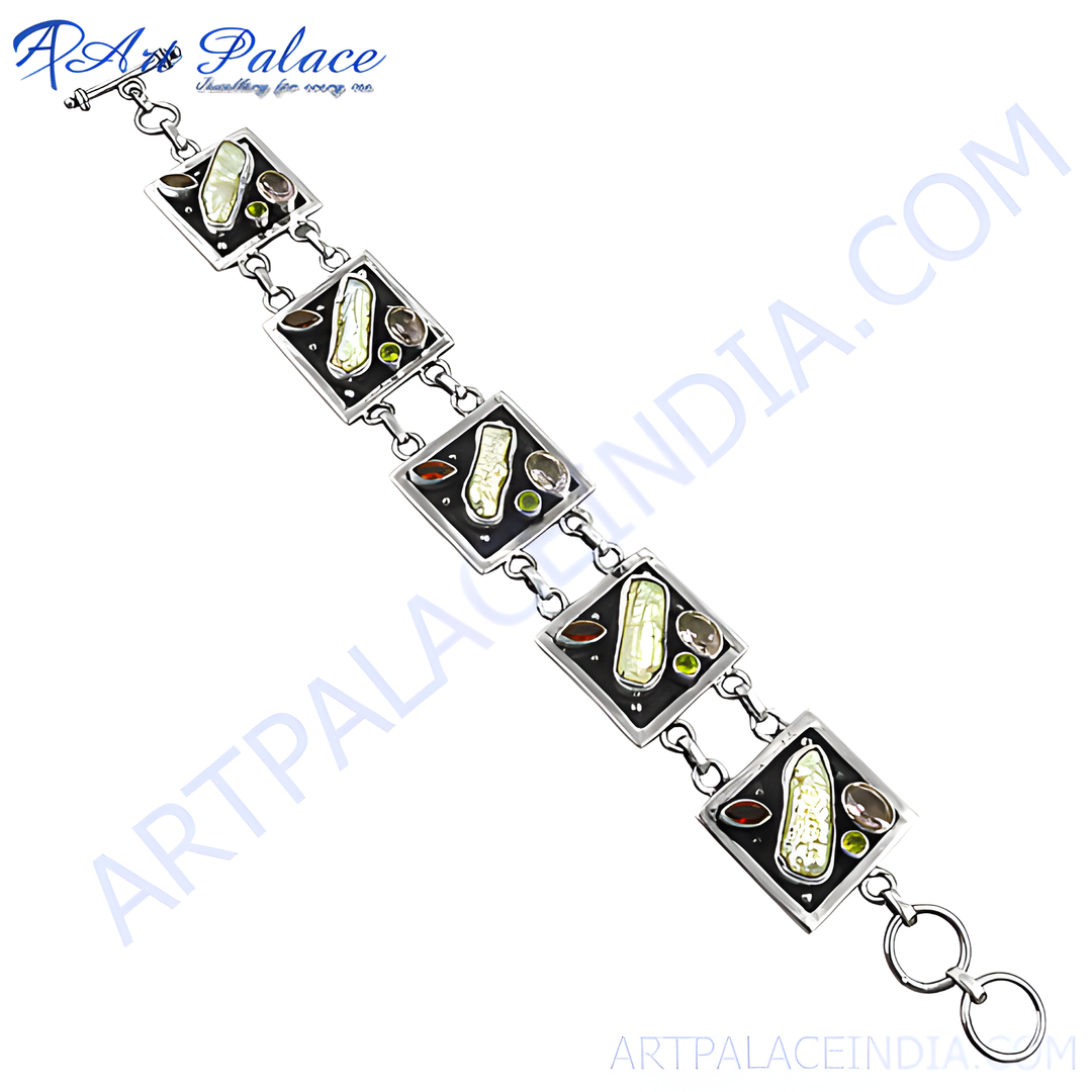 Sterling silver chain bracelet with square links inlaid with gemstones and mother of pearl accents against a white background.