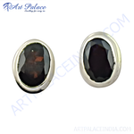 Load image into Gallery viewer, Close-up of silver stud earrings with oval black gemstones set in a silver bezel.
