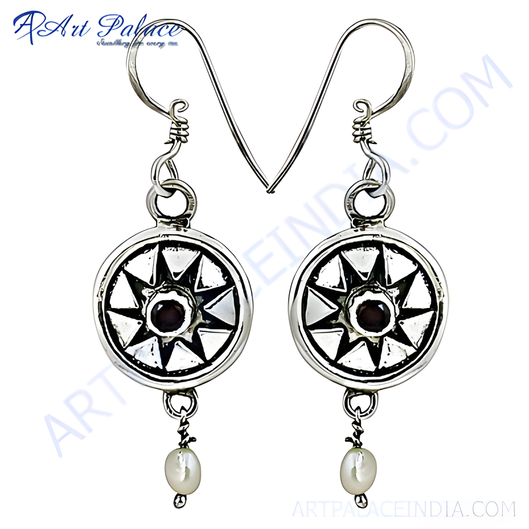 Sterling silver drop earrings featuring a circular design, dark gemstone center, and white pearl drop.