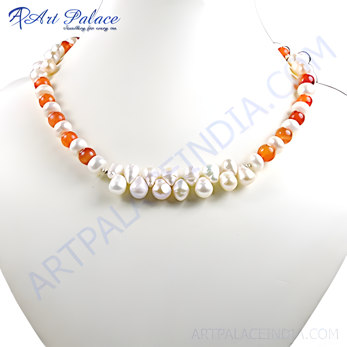 A necklace featuring white pearls and orange carnelian beads on a white surface
