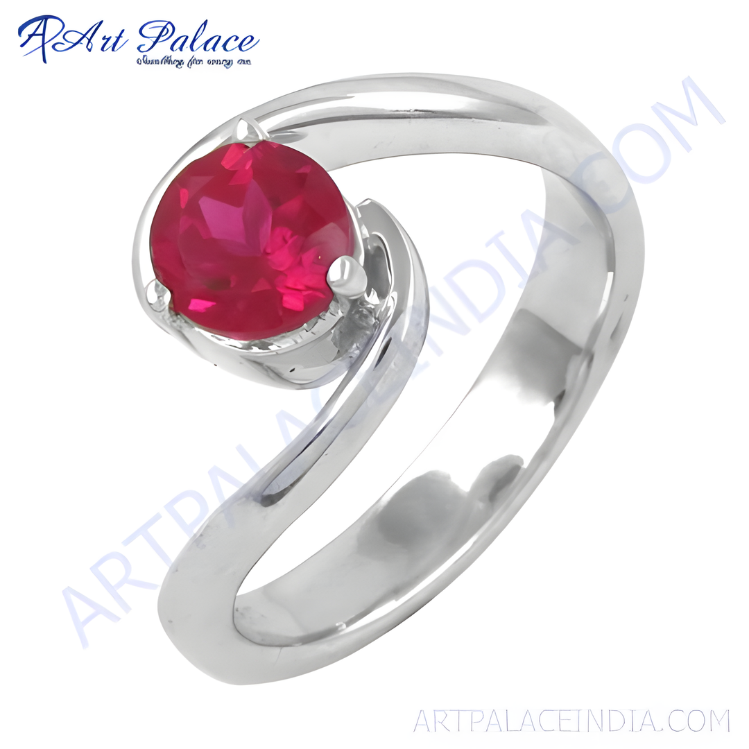 Sterling silver ring with a round, vibrant red ruby gemstone set in a swirl design