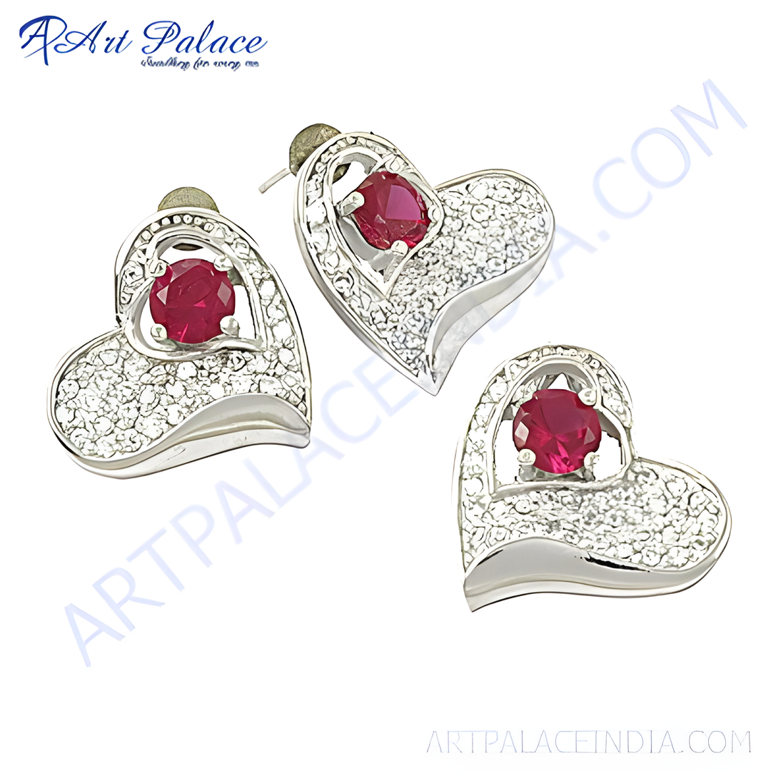 Silver heart-shaped stud earrings with a central red ruby gemstone, perfect for women's jewelry.