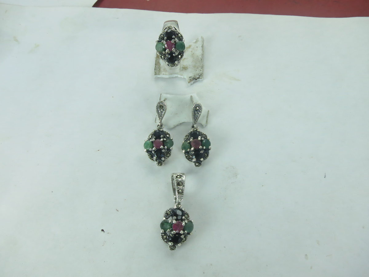 Sterling silver jewelry set with gemstone ring, earrings, and pendant featuring emerald, ruby, and onyx stones