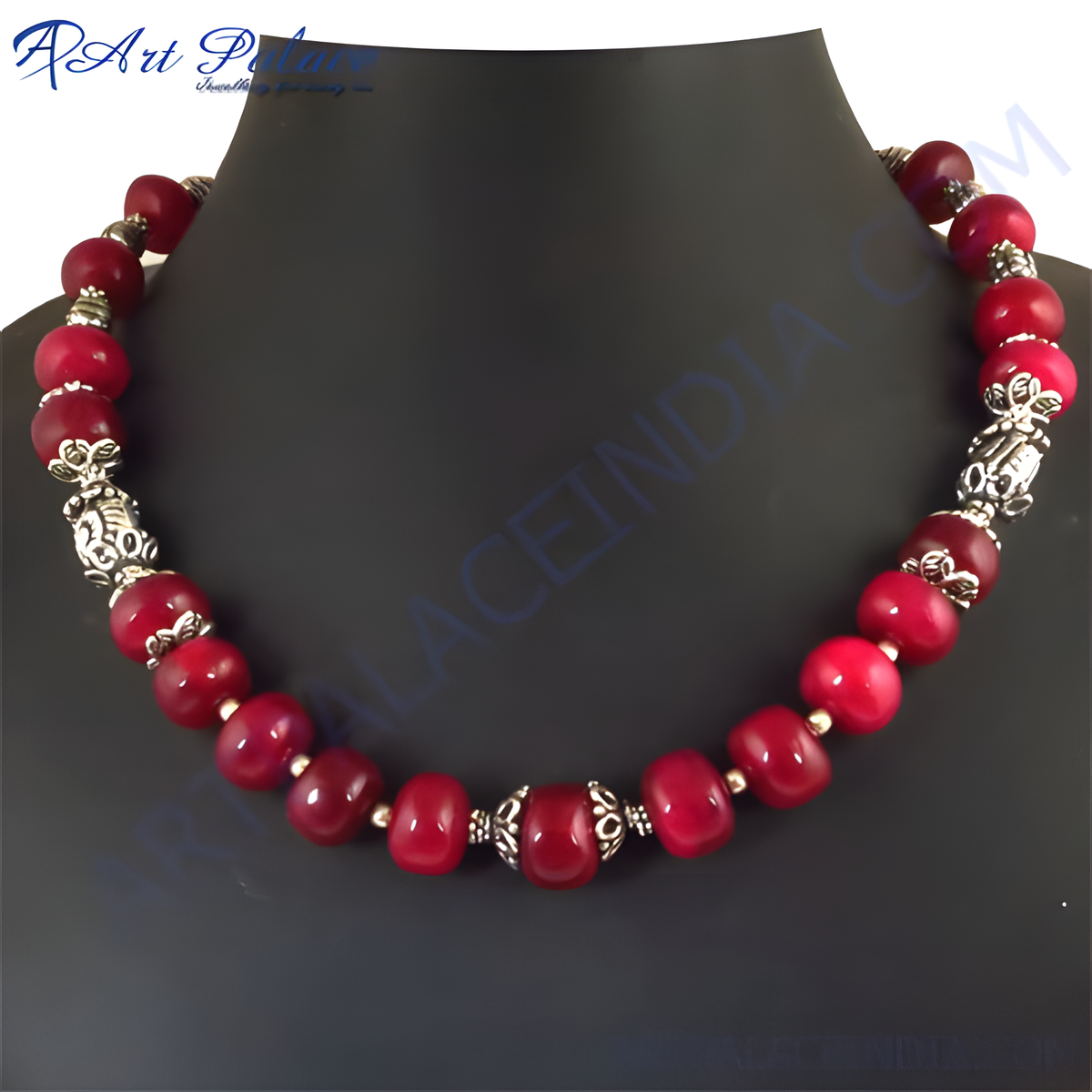 Red beaded necklace on a black jewelry display, showcasing the vibrant red beads and silver accents