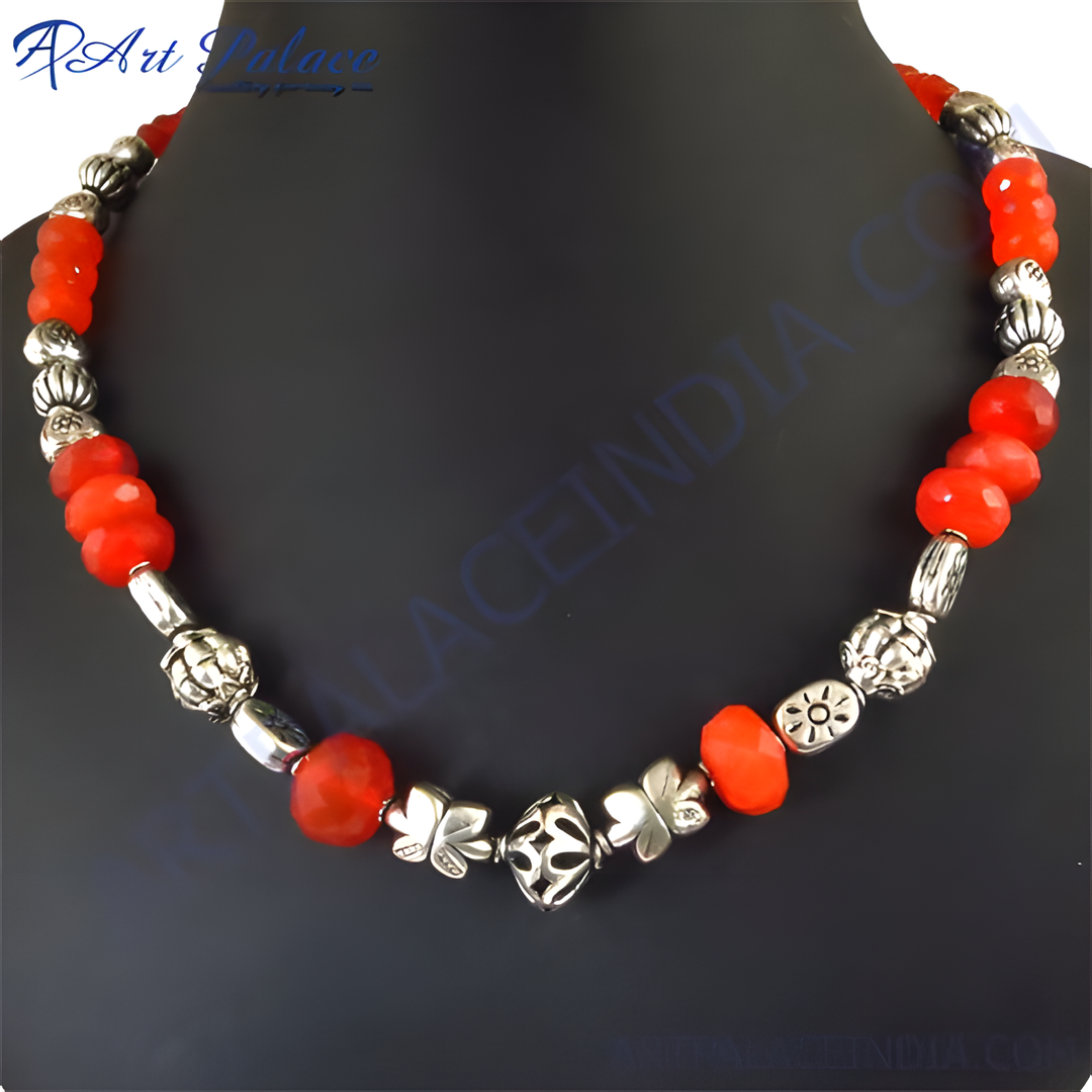 Red gemstone beaded necklace with silver accents on a black background