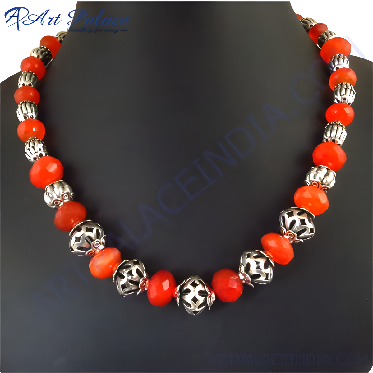Red carnelian bead necklace with sterling silver accents on a black display